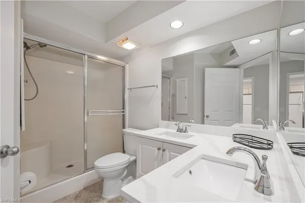 a bathroom with a double vanity sink toilet and shower