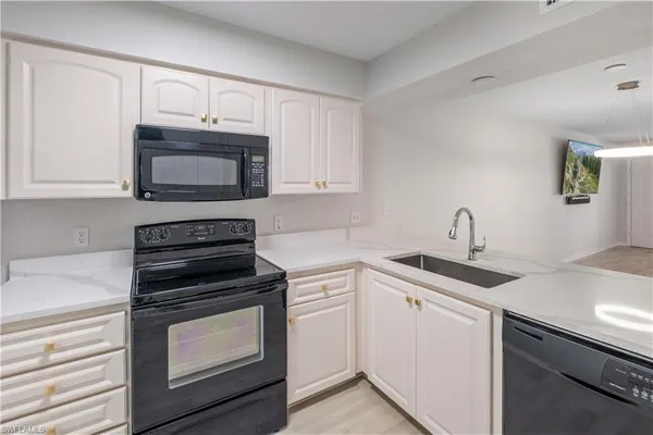 a kitchen with cabinets stainless steel appliances and a sink