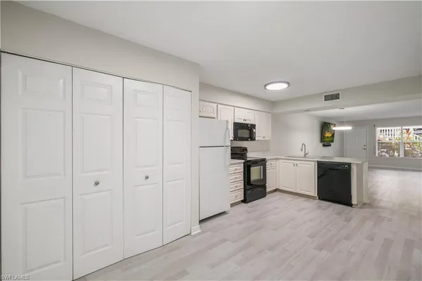 a view of a kitchen with stainless steel appliances refrigerator and cabinets