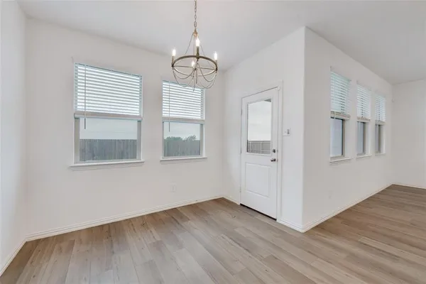 a view of empty room with wooden floor and window