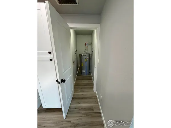 a view of a hallway with wooden floor and stairs