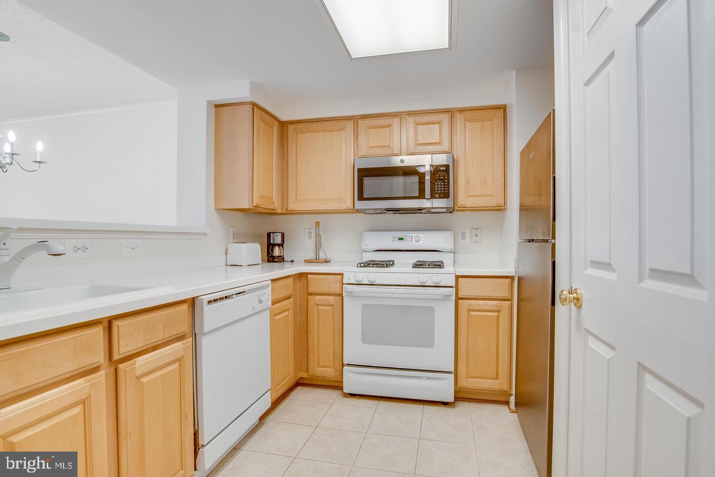 a kitchen with stainless steel appliances granite countertop a sink and dishwasher a refrigerator with white cabinets