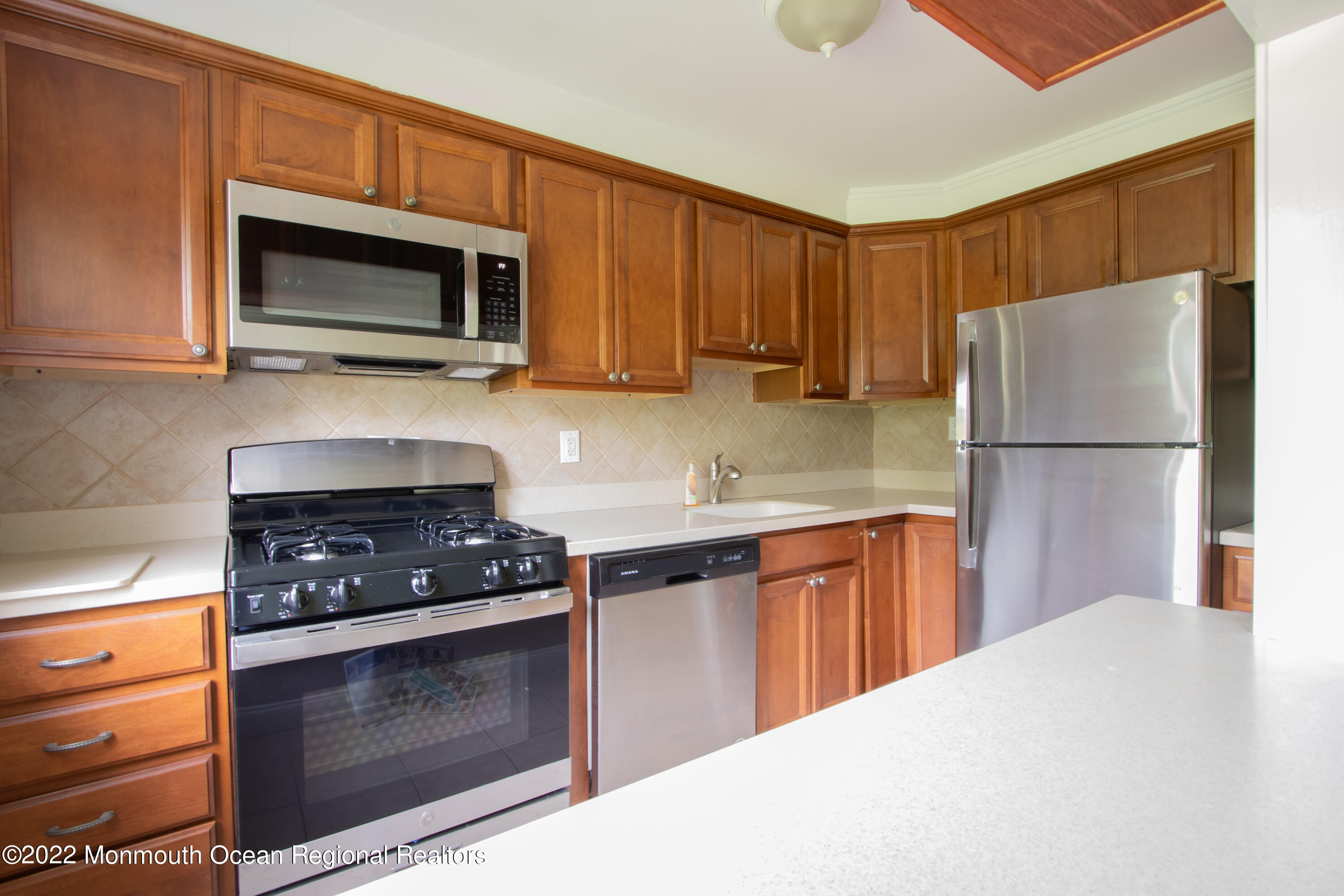 27 Manor Drive Red Bank, NJ 07701 - Photo 8 of 17 a kitchen with stainless steel appliances granite countertop a stove microwave and refrigerator