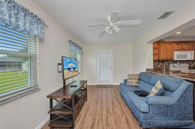 a living room with furniture and a wooden floor