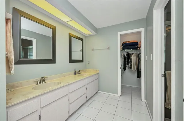 a en suite bathroom with a granite countertop sink and a mirror