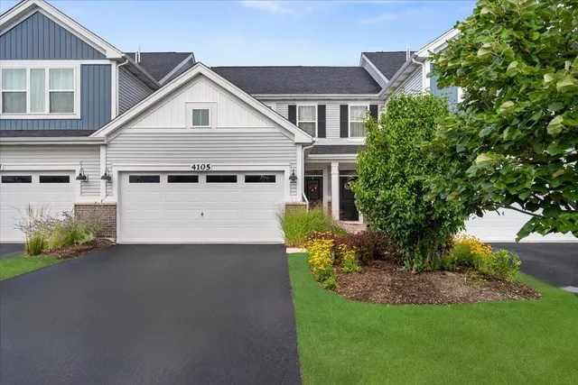 a view of a house with a small yard and a large tree