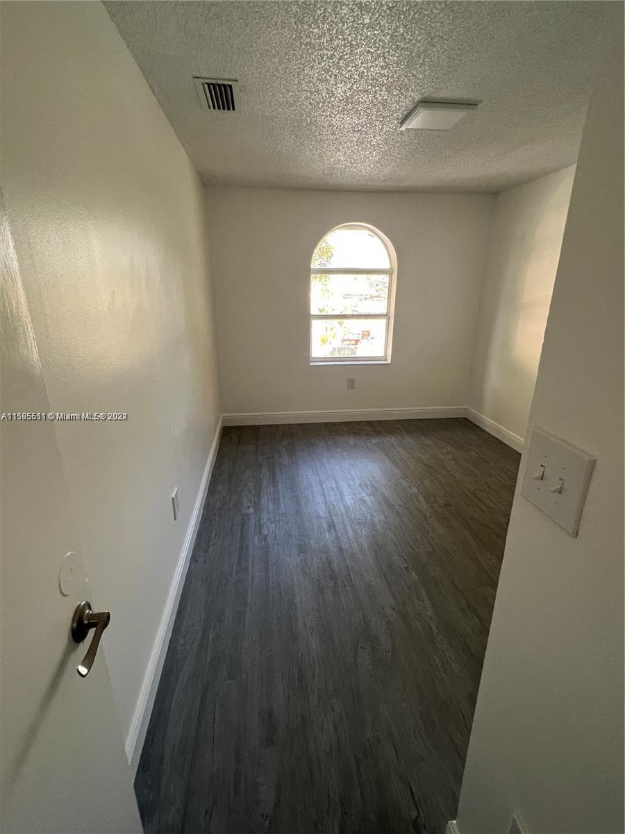 2050 Southwest 122nd Avenue, Unit 22 Miami, FL 33175 - Photo 14 of 24 an empty room with wooden floor and windows