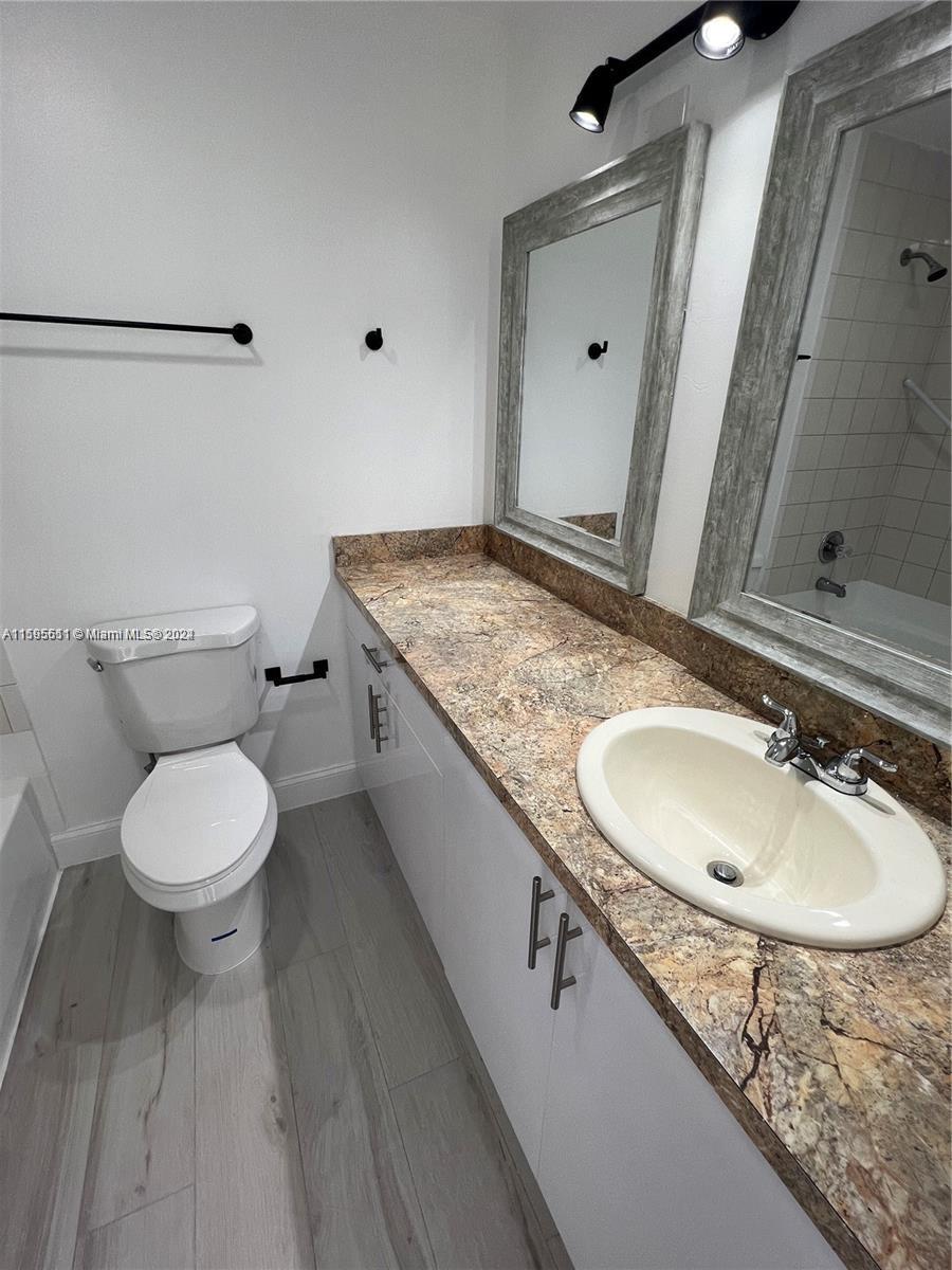 2050 Southwest 122nd Avenue, Unit 22 Miami, FL 33175 - Photo 23 of 24 a bathroom with a granite countertop sink toilet and mirror