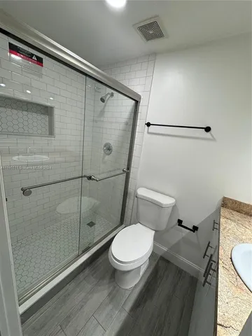 a white toilet sitting next to a shower