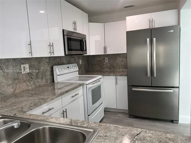 a kitchen with a sink and stainless steel appliances