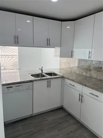 a kitchen with granite countertop white cabinets and white appliances