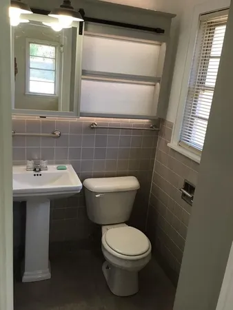 a bathroom with a toilet sink and mirror