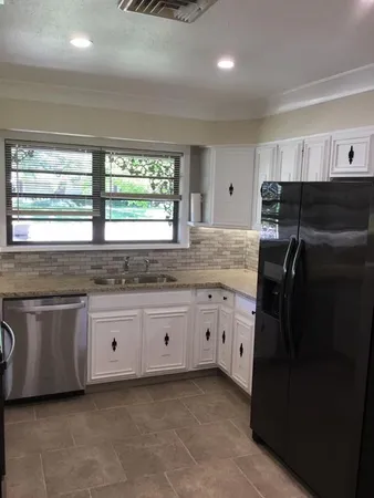 a kitchen with granite countertop a refrigerator and a sink