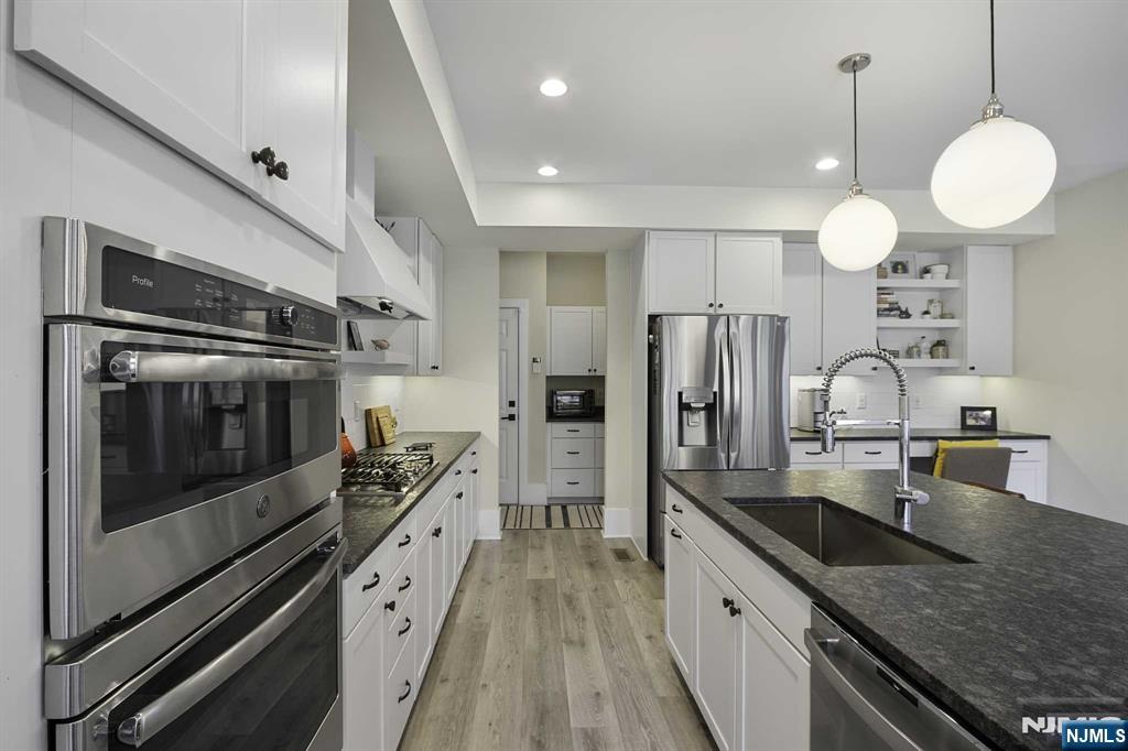 10 Aspen Drive Cedar Grove, NJ 07009 - Photo 11 of 43 a kitchen with stainless steel appliances granite countertop a sink a stove and a refrigerator