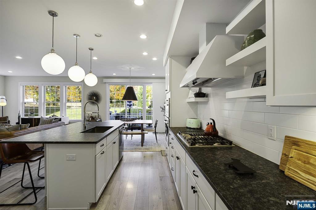 10 Aspen Drive Cedar Grove, NJ 07009 - Photo 13 of 43 a kitchen with stainless steel appliances granite countertop a sink a stove and a wooden floors