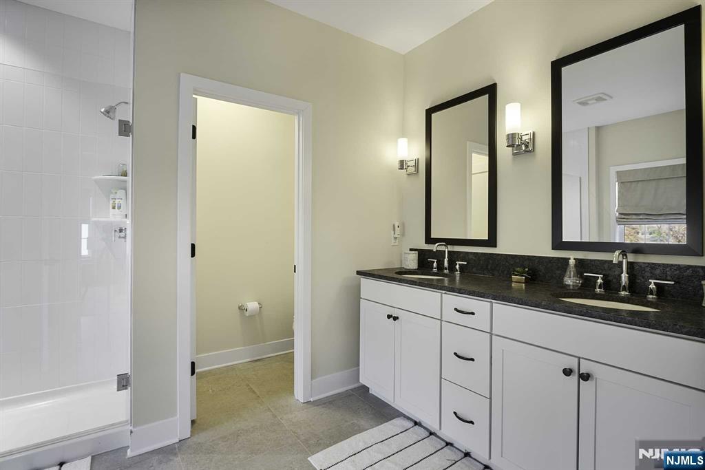 10 Aspen Drive Cedar Grove, NJ 07009 - Photo 24 of 43 a bathroom with double sink and a mirror