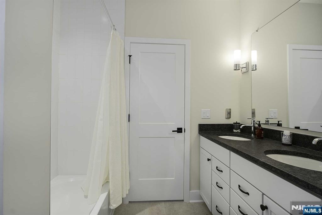 10 Aspen Drive Cedar Grove, NJ 07009 - Photo 27 of 43 a bathroom with double sink and a mirror