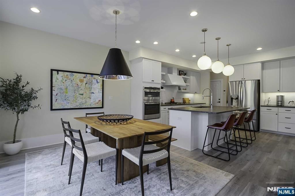 10 Aspen Drive Cedar Grove, NJ 07009 - Photo 8 of 43 a kitchen with kitchen island a dining table and chairs