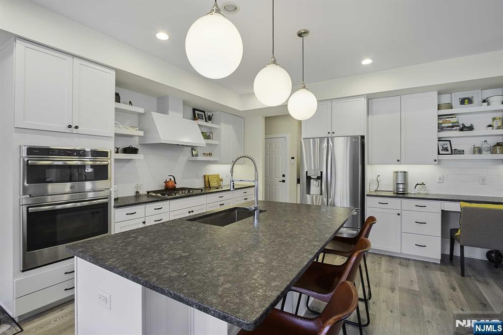 10 Aspen Drive Cedar Grove, NJ 07009 - Photo 10 of 43 a kitchen with stainless steel appliances granite countertop a stove a sink a refrigerator a stove and white cabinets