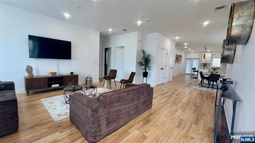 367 Devon Street, Unit 2 Kearny, NJ 07032 - Photo 5 of 30 a living room with furniture a flat screen tv and kitchen view