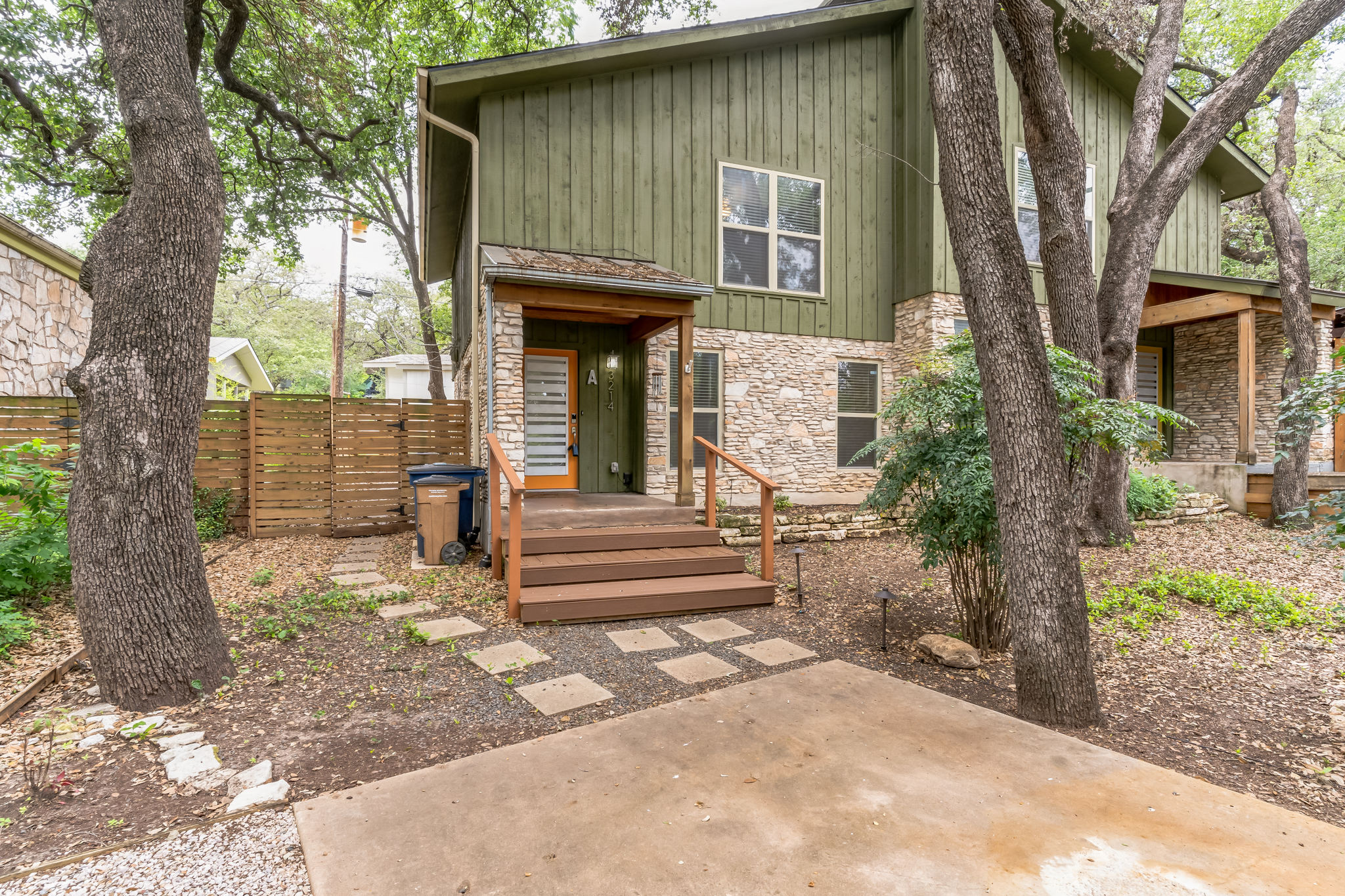 A charming exterior with a blend of wood siding and natural stone accents, nestled amongst mature trees.