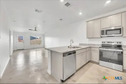a kitchen with stainless steel appliances granite countertop a stove and a sink