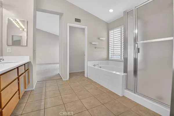 a spacious bathroom with a shower a sink and a mirror