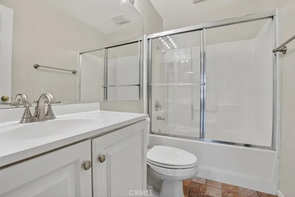 a white toilet next to a bathroom