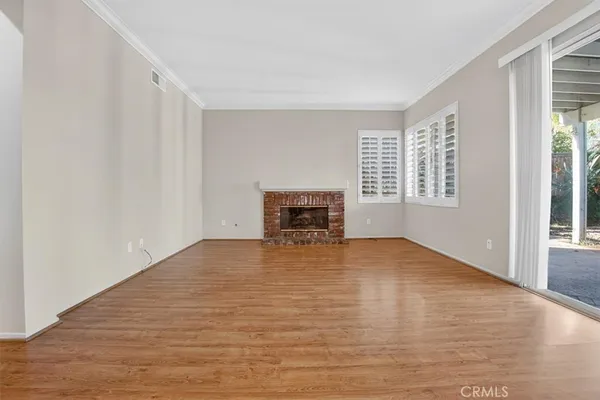 a view of empty room with wooden floor and fireplace