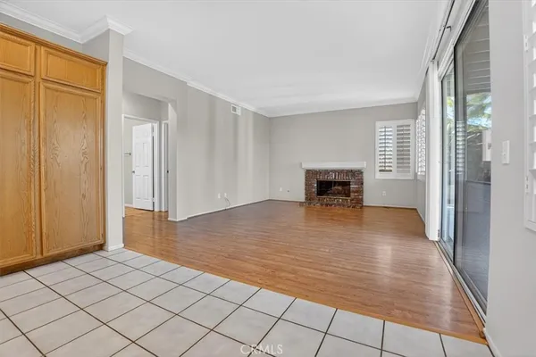 a view of empty room with wooden floor and fireplace