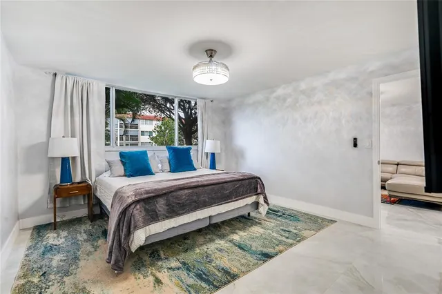 a bedroom with a bed and a large window