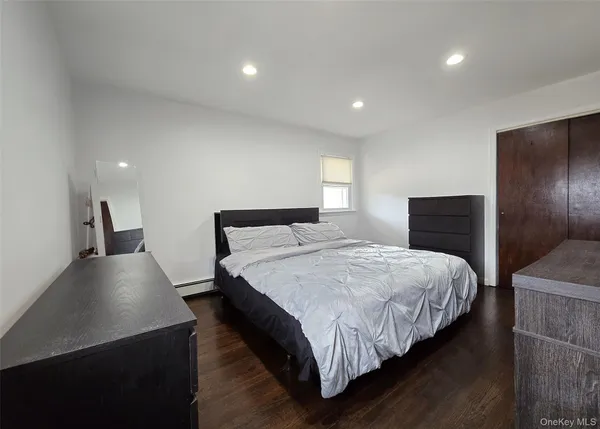 a bedroom with bed and wooden floor