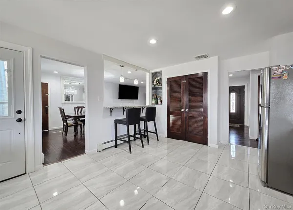 a view of kitchen with stainless steel appliances kitchen island granite countertop cabinets and chandelier