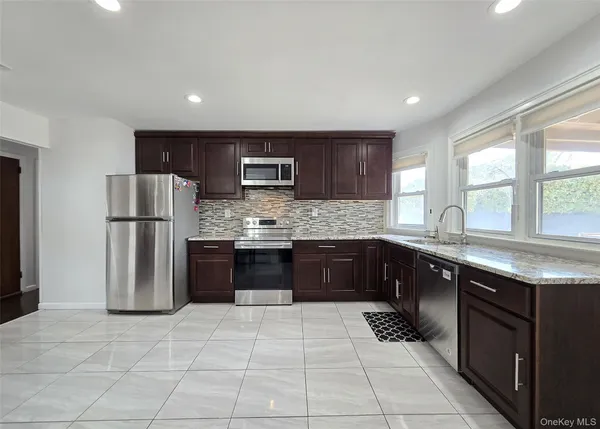 a kitchen with stainless steel appliances granite countertop a refrigerator and a sink
