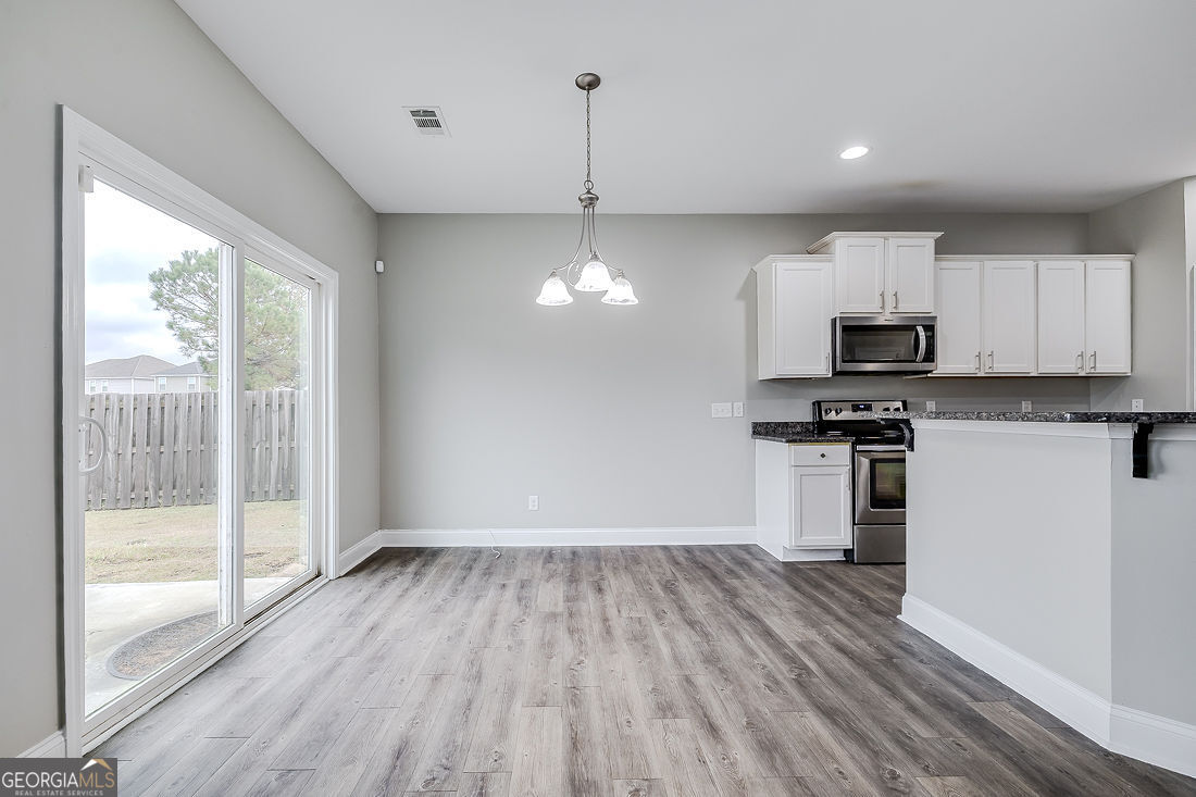 4 Bridlington Way Savannah, GA 31407 - Photo 17 of 38 a kitchen with wooden floors appliances and cabinets