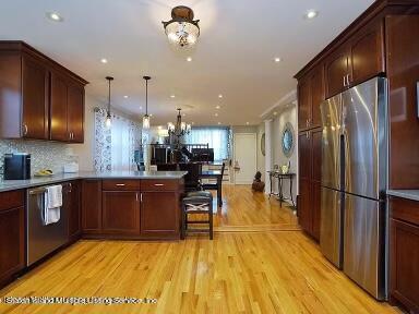 a kitchen with stainless steel appliances wooden floor dining table and chairs