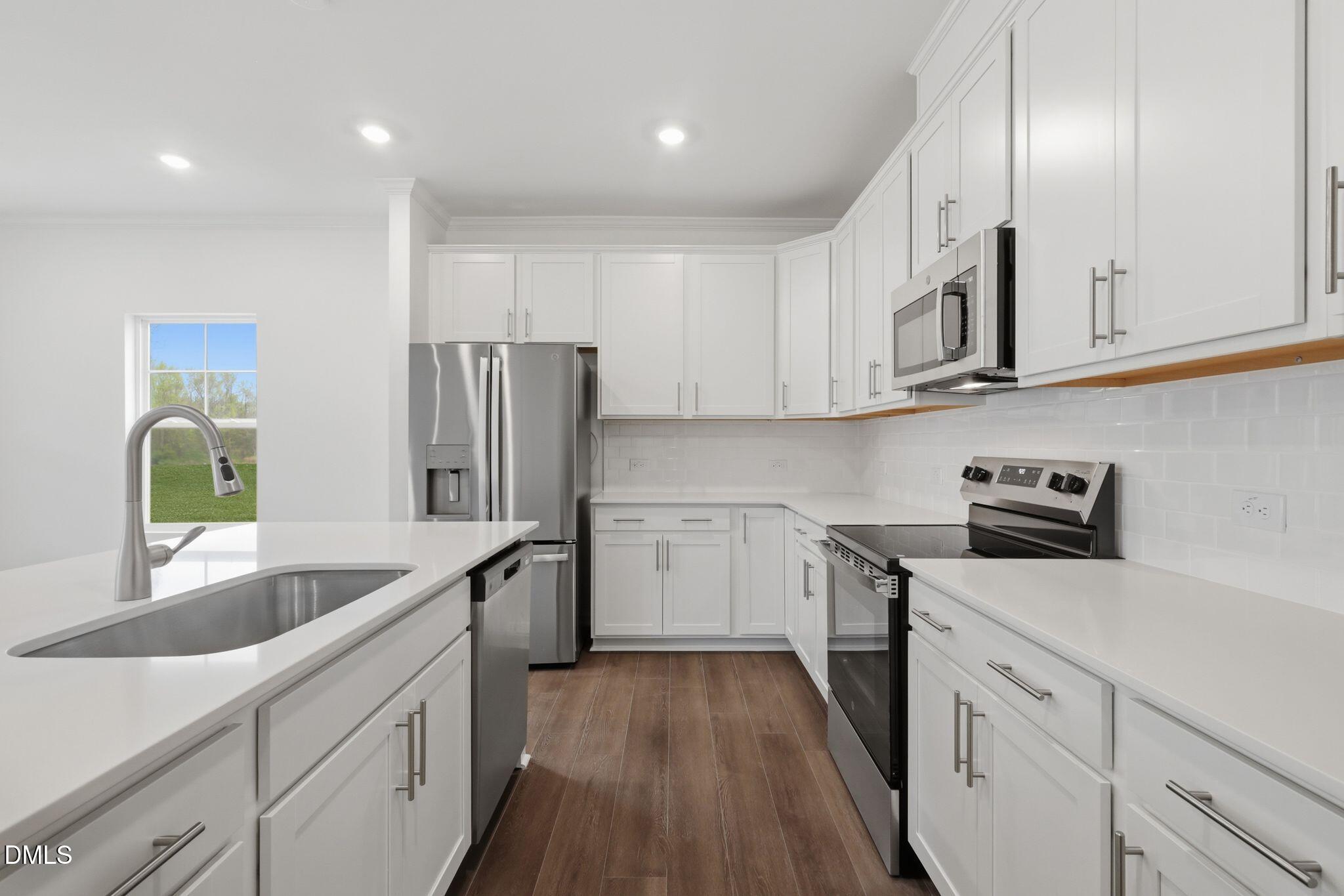 155 Digging Time Avenue Princeton, NC 27569 - Photo 11 of 29 a kitchen with white cabinets and stainless steel appliances