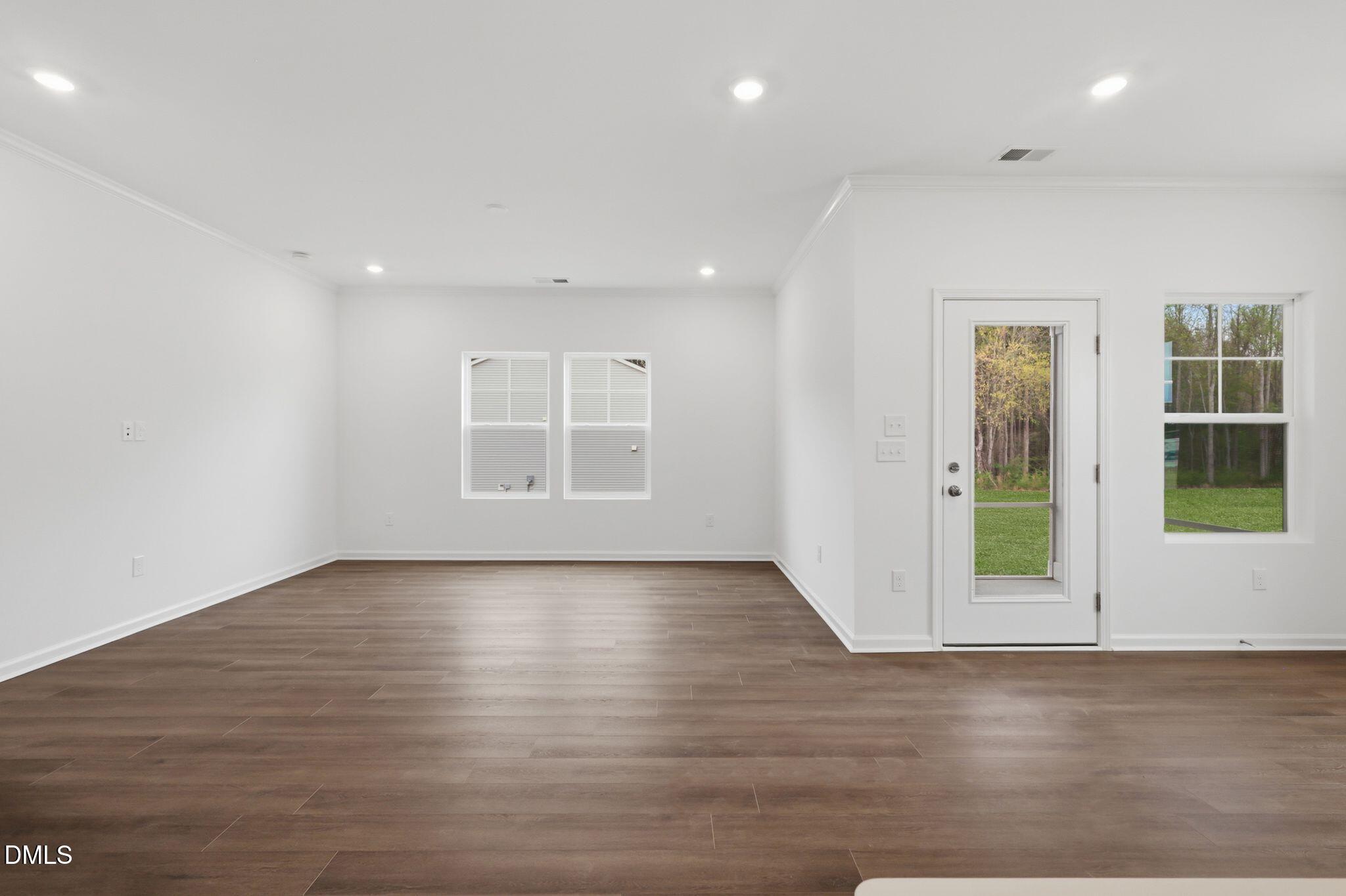 155 Digging Time Avenue Princeton, NC 27569 - Photo 15 of 29 an empty room with wooden floor and windows
