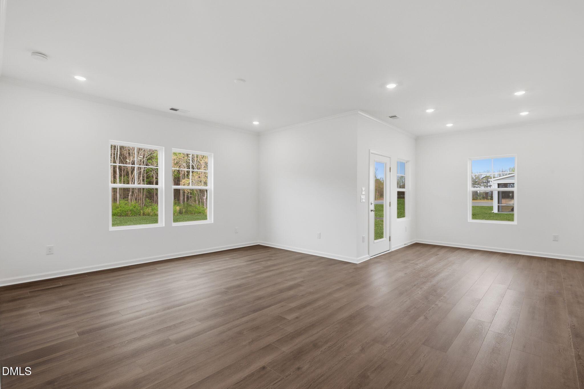 155 Digging Time Avenue Princeton, NC 27569 - Photo 5 of 29 a view of an empty room with wooden floor and windows