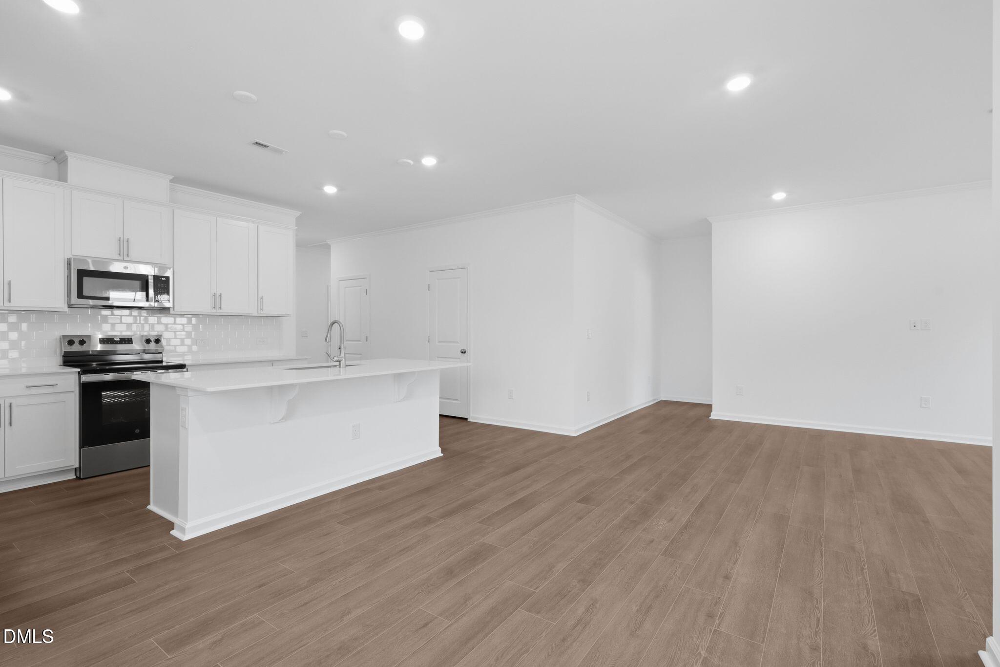 155 Digging Time Avenue Princeton, NC 27569 - Photo 8 of 29 a kitchen with granite countertop white cabinets and stainless steel appliances