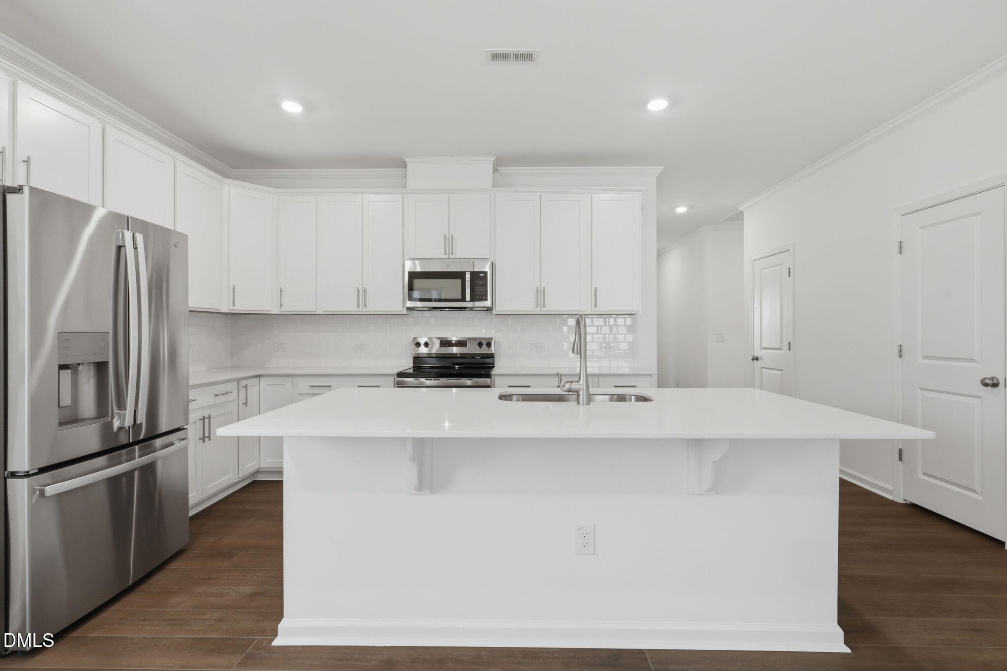 155 Digging Time Avenue Princeton, NC 27569 - Photo 10 of 29 a kitchen with kitchen island white cabinets and stainless steel appliances