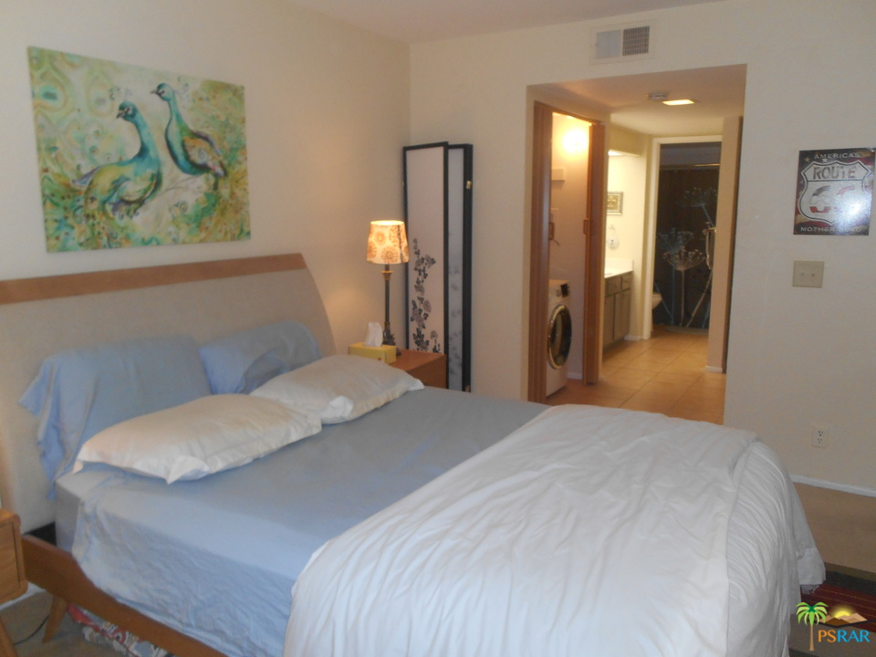 1050 Ramon Road, Unit 20 Palm Springs, CA 92264 - Photo 17 of 35 a bedroom with a bed and a painting on the wall