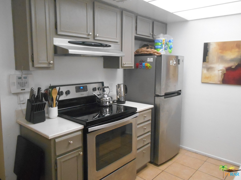 1050 Ramon Road, Unit 20 Palm Springs, CA 92264 - Photo 6 of 35 a kitchen with stainless steel appliances granite countertop a refrigerator a stove and a sink