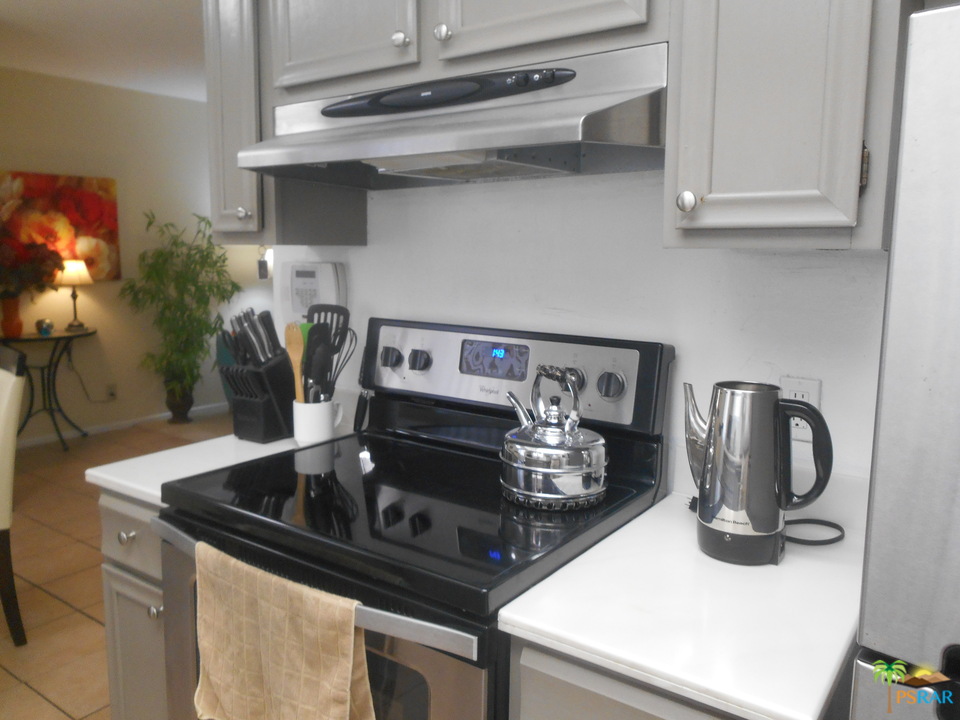 1050 Ramon Road, Unit 20 Palm Springs, CA 92264 - Photo 7 of 35 a kitchen with a stove and a wooden floor
