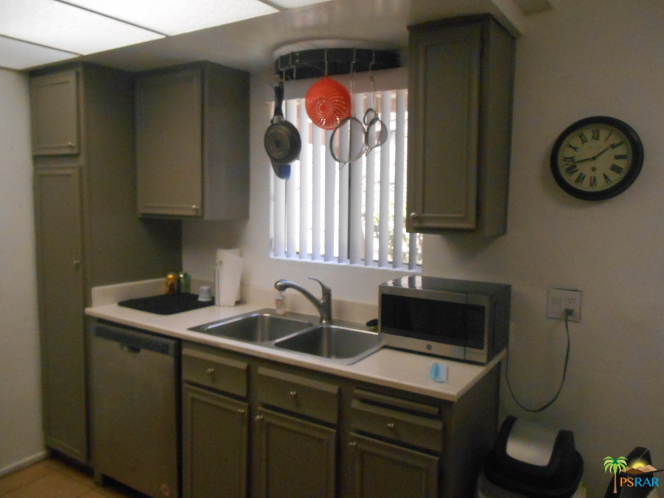 1050 Ramon Road, Unit 20 Palm Springs, CA 92264 - Photo 9 of 35 a kitchen with a sink a stove and a wall painting