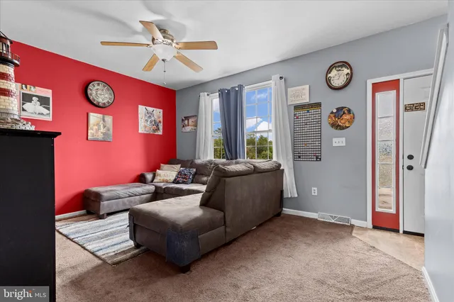 a living room with furniture a window and a ceiling fan