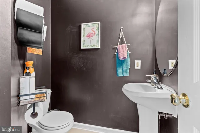 a bathroom with a sink vanity mirror and toilet