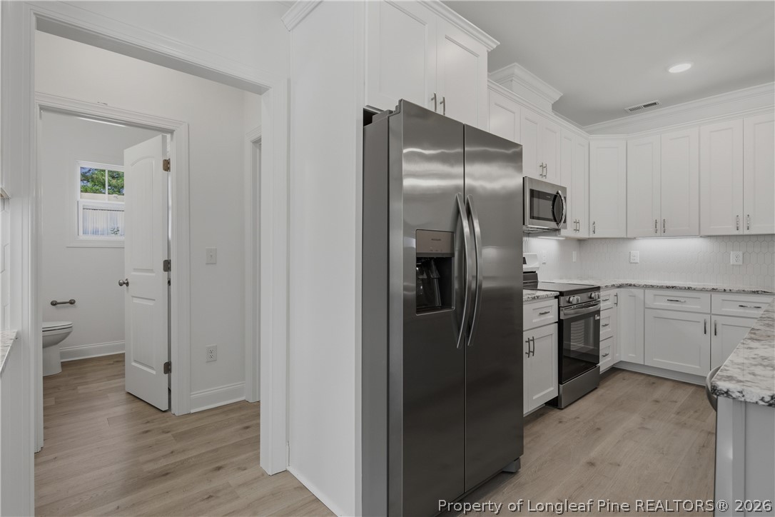 3223 Leaflet Church Road Broadway, NC 27505 - Photo 12 of 30 a kitchen with a refrigerator sink and cabinets