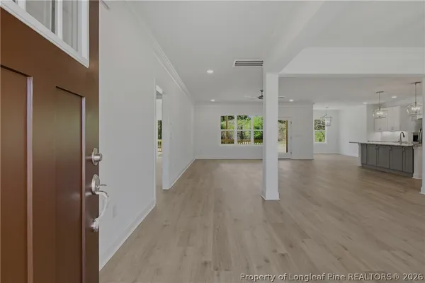 a view of a big room with wooden floor and windows
