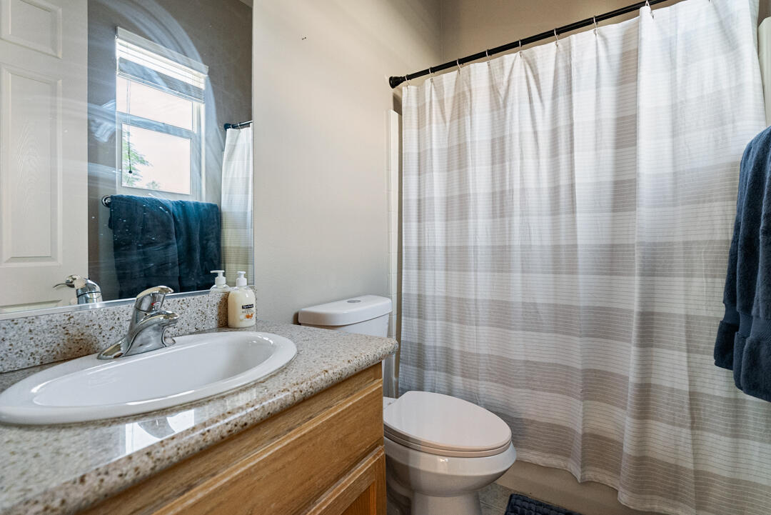 49418 Wayne Street Indio, CA 92201 - Photo 18 of 22 a bathroom with a granite countertop sink and a mirror